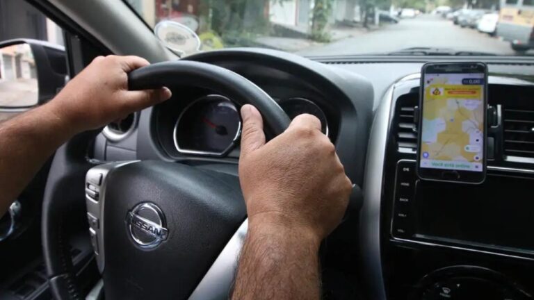 Painel de carro com motorista com as mãos no volante